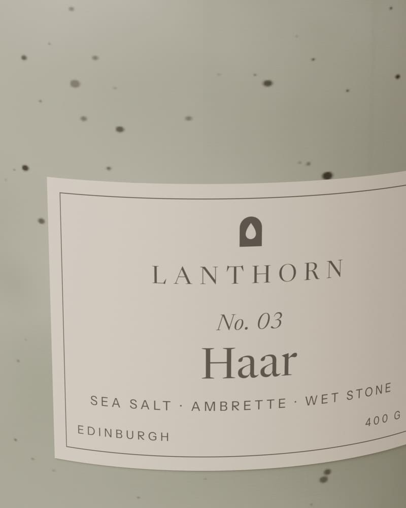 Close view of the Haar label on the pale celadon glaze, speckled with small dark flecks of iron.