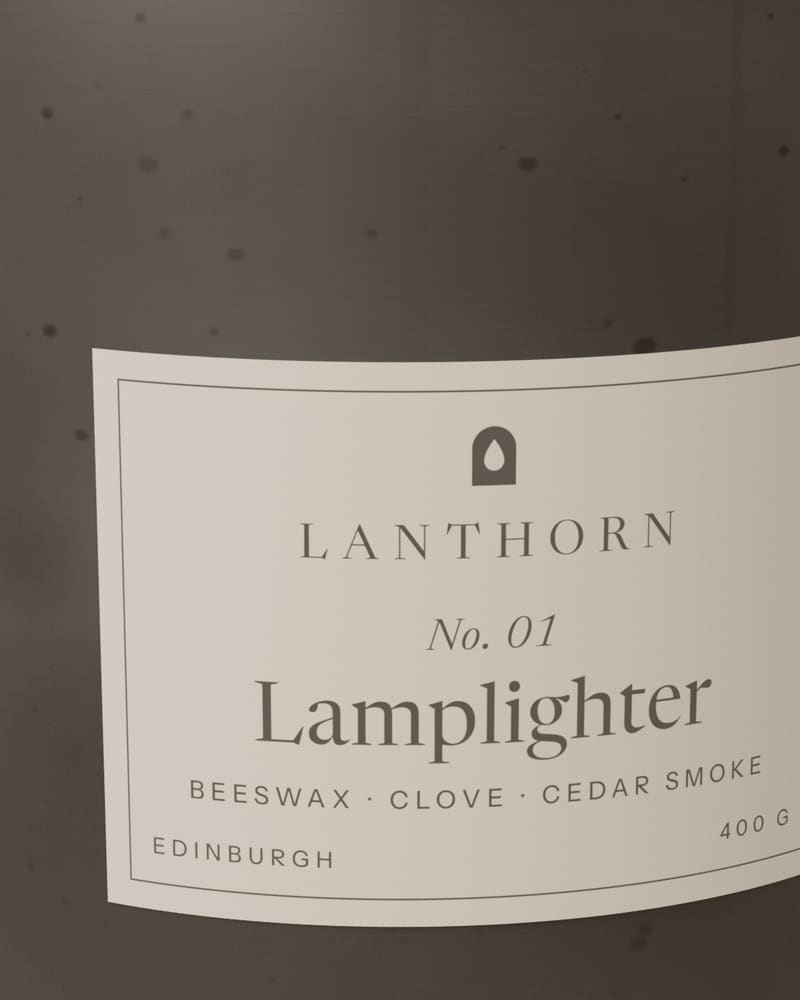 Close view of the Lamplighter paper label on speckled charcoal glaze, showing the arched Lanthorn mark and “No. 01”.